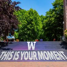 Outside staircase that reads "W: This is Your Moment." Trees in the background.